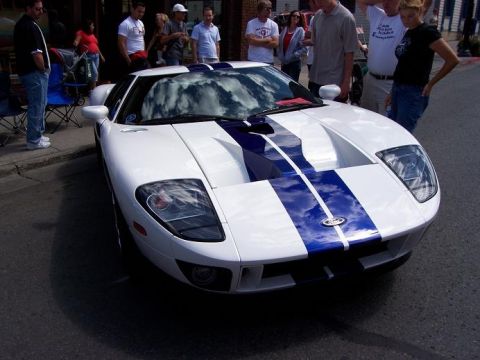 1972 Ford Ranchero - White Ford GT sports car with blue stripes parked on street, front view.