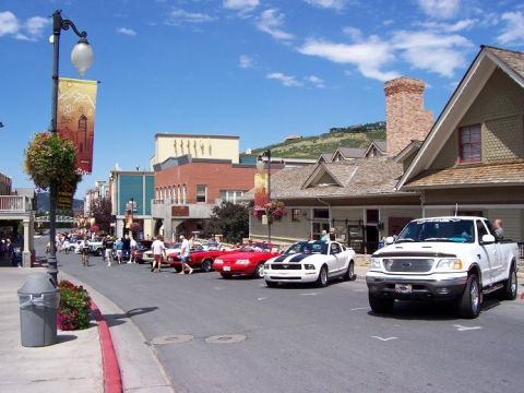 1972 Ford Ranchero - A white Ford F-150 pickup truck is parked on a street lined with buildings and other vehicles.