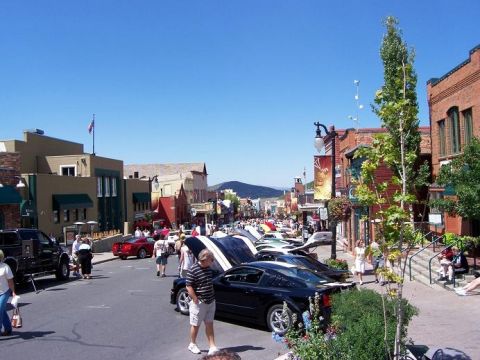 1972 Ford Ranchero - A sunny day in a town square features a car show with many vehicles displayed along the street.