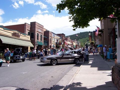1972 Ford Ranchero - Cars are displayed on a street lined with shops and people.