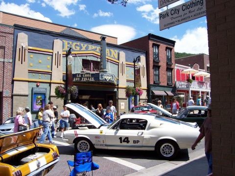 1972 Ford Ranchero - A white 1967 muscle car with racing stripes and number 14 is parked on a street in front of the Egyptian theater.