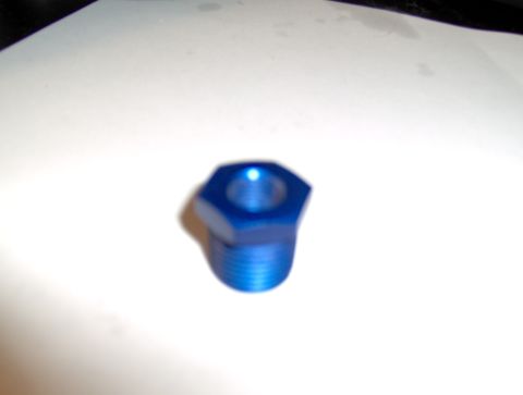 1978 Ford Bronco - A close-up view of a small, blue, hexagonal metal fitting with visible threads.