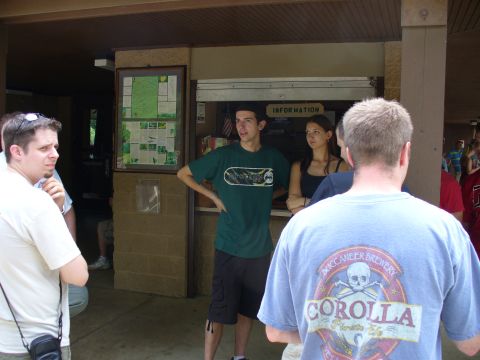 1991 Ford Probe - Several people are standing around an information booth, some looking at a map display.