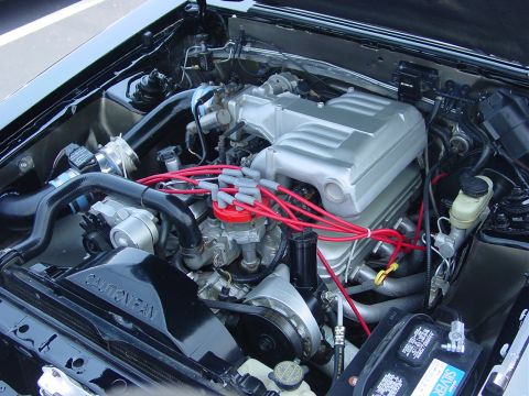 1986 Ford Mustang - Engine bay of a 1986 Ford Mustang, showing the intake manifold and wiring.