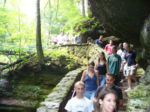 1991 Ford Probe - A group of people are walking down a stone staircase in a lush, green forest setting.