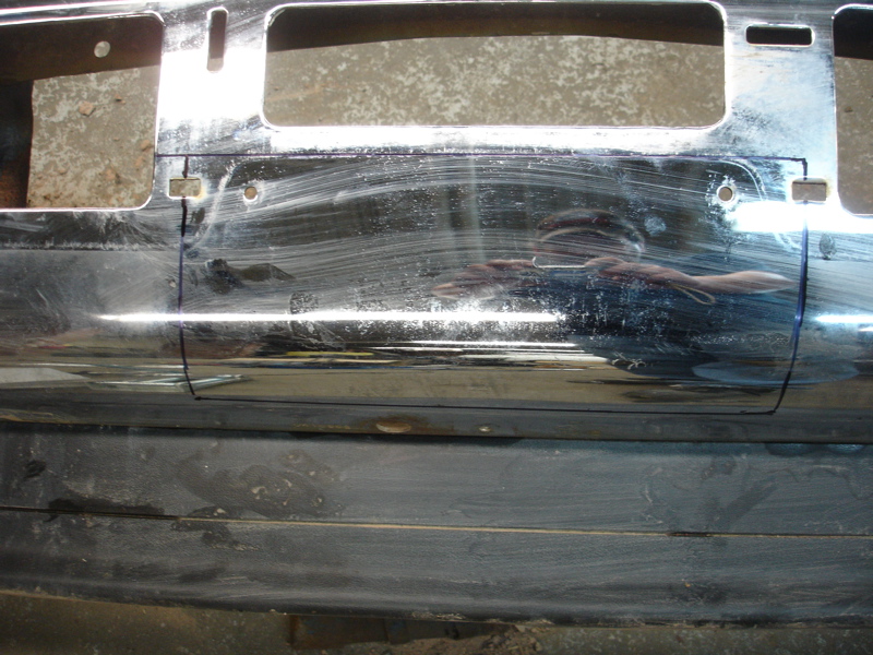 Chrome bumper section with two rectangular openings and visible scratch marks