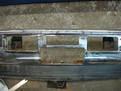 1996 Ford Bronco - Chrome bumper with cutouts for winch installation, showing rust on the mounting plates.