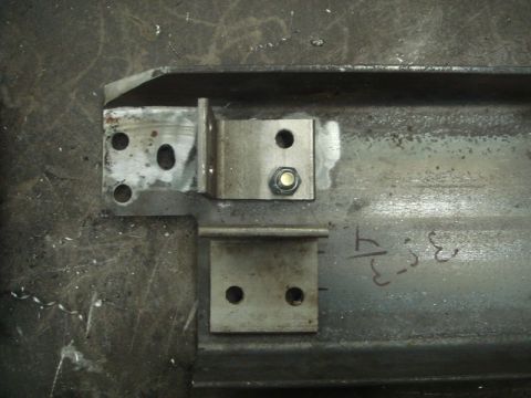 1996 Ford Bronco - Close-up view of metal brackets attached to a steel beam, possibly part of a winch installation.