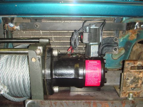 1996 Ford Bronco - Close-up of a vehicle's front-mounted winch, including its motor and warning sticker.