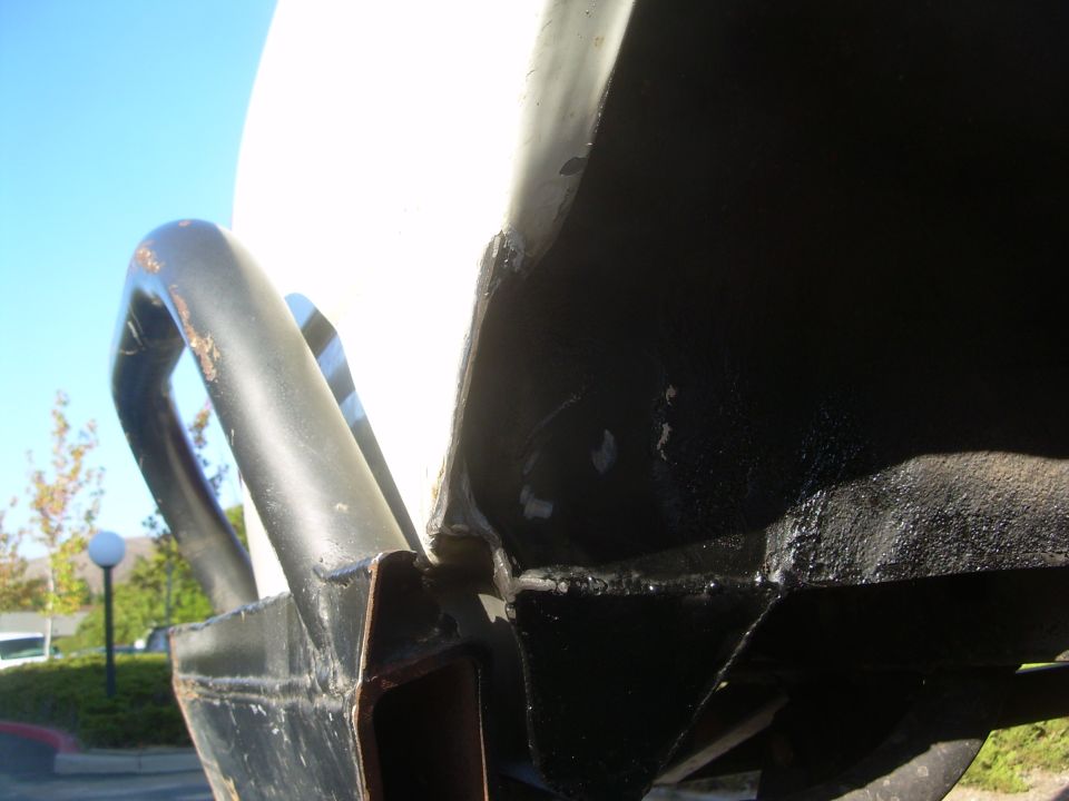 Rear bumper and frame detail with rust on metal bar