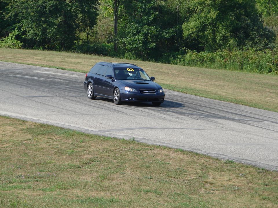 Dark blue Subaru Legacy wagon with racing number 03 on windshield, on a race track