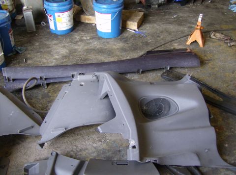 1996 Ford Probe - Disassembled car interior components are laid out on a garage floor.