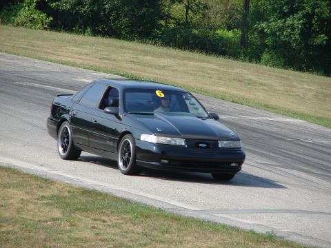1993 Ford Taurus - A black 1993 Ford Taurus is seen on a race track, displaying the number 6 on its windshield.
