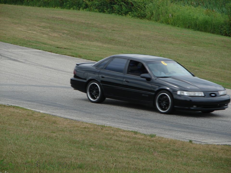Black 1993 Ford Taurus on a race track with number 6 on windshield