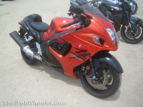 1990 Ford Bronco - orange and black Suzuki Hayabusa sportbike parked on packed dirt, with a blue and black sportbike visible behind it.