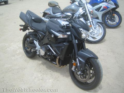 1990 Ford Bronco - black Suzuki naked streetfighter-style motorcycle parked on dirt, with a silver and a blue Suzuki sportbike behind it.