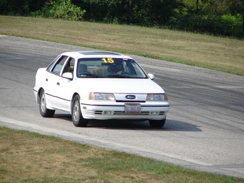1993 Ford Taurus - White 1993 Ford Taurus with racing number 15 on the windshield navigates a turn on a track.