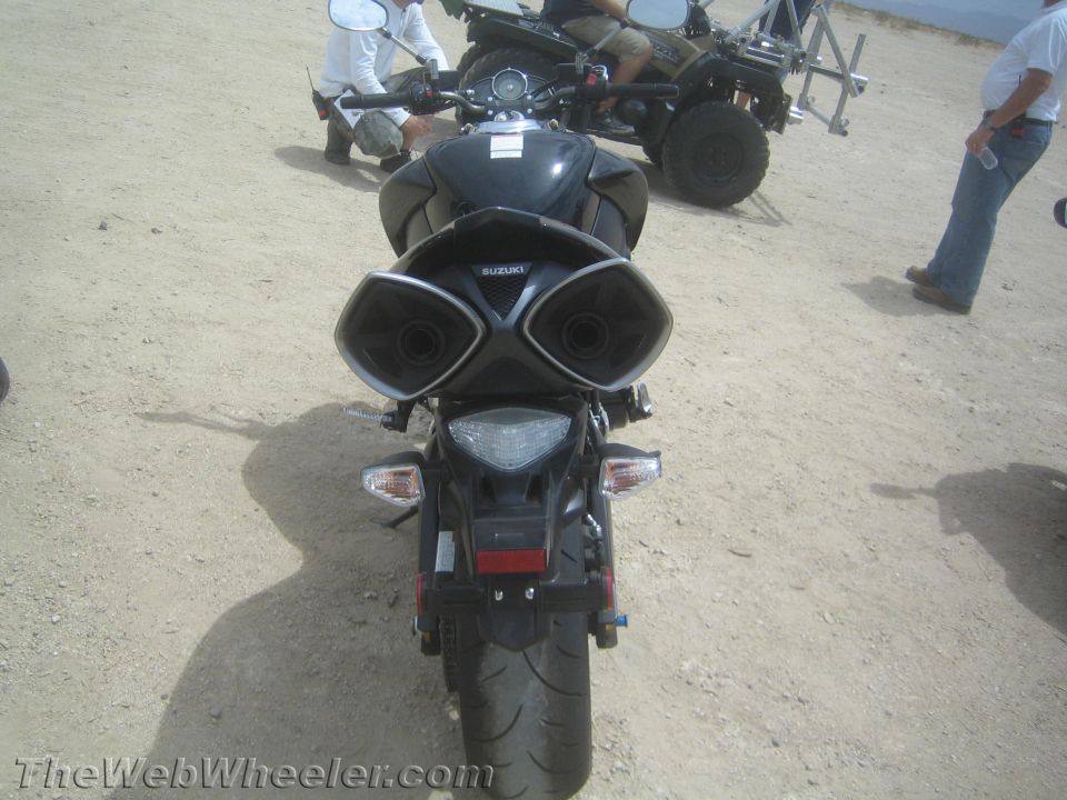 Rear view of black Suzuki sportbike showing dual exhaust and taillight