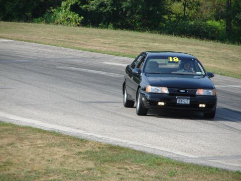 1993 Ford Taurus - A black 1993 Ford Taurus is seen on a race track with the number 19 displayed on its windshield.