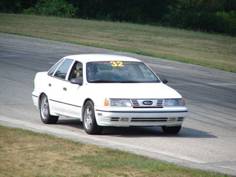 1993 Ford Taurus - A white 1993 Ford Taurus with racing number 32 is seen on the track during a sunny day.