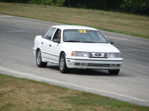 1993 Ford Taurus - A white 1993 Ford Taurus is seen on a race track, displaying the number 32 on its windshield.