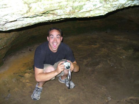 1991 Ford Probe - Man with a surprised expression holds a camera while exploring a cave.
