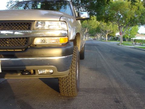 2002 Chevrolet Silverado 2500 - A tan 2002 Chevrolet Silverado 2500 is parked on a residential street, viewed from the front quarter angle.