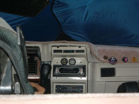 1981 Ford Bronco - The dashboard of a vehicle features multiple gauges and an aftermarket stereo system.