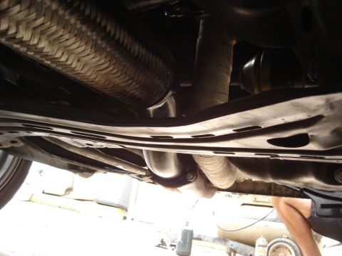 1995 Mazda MX-6 - Close-up view of the exhaust system and undercarriage components of a vehicle.