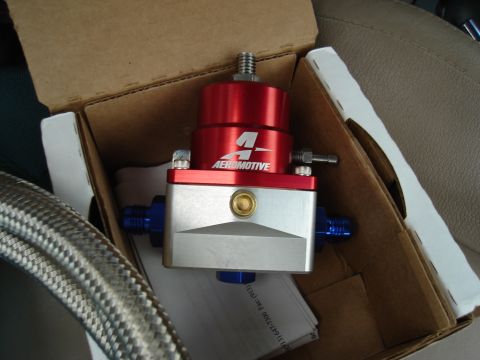 1995 Mazda MX-6 - Aeromotive fuel pressure regulator in its box, next to a braided hose and car seat.