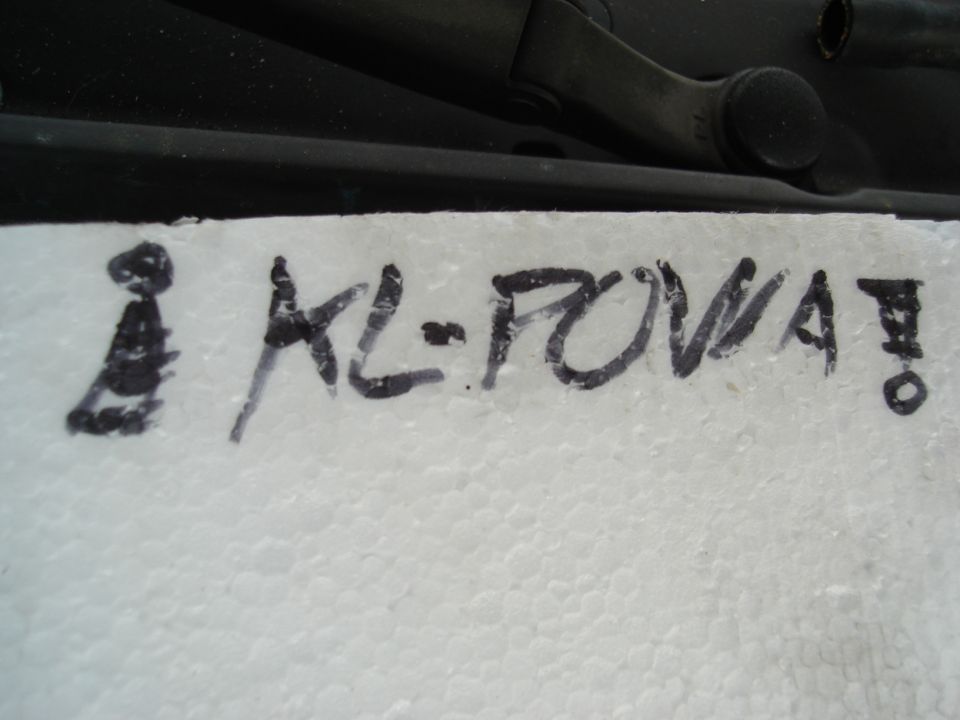 Handwritten text KL-POWA! on white surface