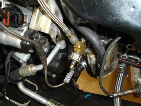 1995 Mazda MX-6 - Engine bay components including hoses, sensors, and metal fittings are visible in this close-up shot.