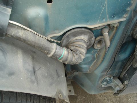 1995 Mazda MX-6 - A flexible rubber grommet with a braided wire is visible in the engine bay of a vehicle.