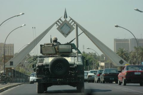 1996 Ford Bronco - A military vehicle with a mounted weapon is seen on a road with other traffic, under a large abstract monument.