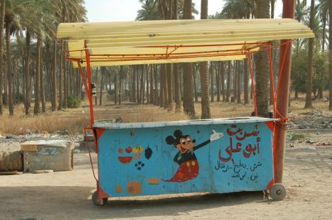 1996 Ford Bronco - A colorful food cart decorated with Mickey Mouse and Arabic script stands in an outdoor setting.