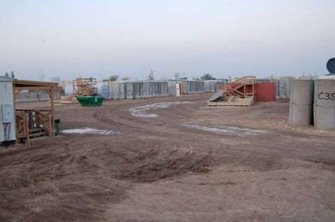 1996 Ford Bronco - A wide shot of a military installation shows rows of concrete barriers and a green dumpster in the foreground.