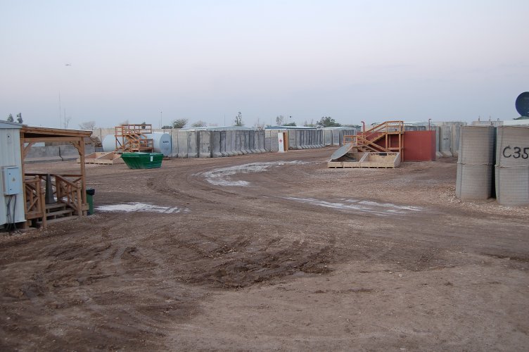 Military base scene with concrete barriers and a green dumpster