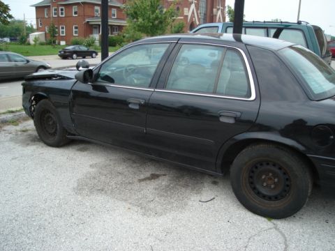 2000 Ford Crown Victoria - Side view of a black 2000 Ford Crown Victoria showing damage to the front end.