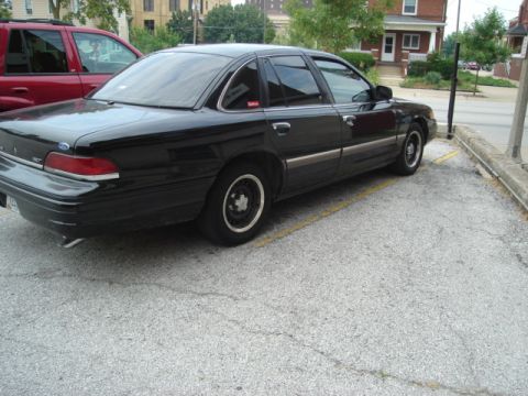2000 Ford Crown Victoria - Side view of a black 2000 Ford Crown Victoria parked in a lot.