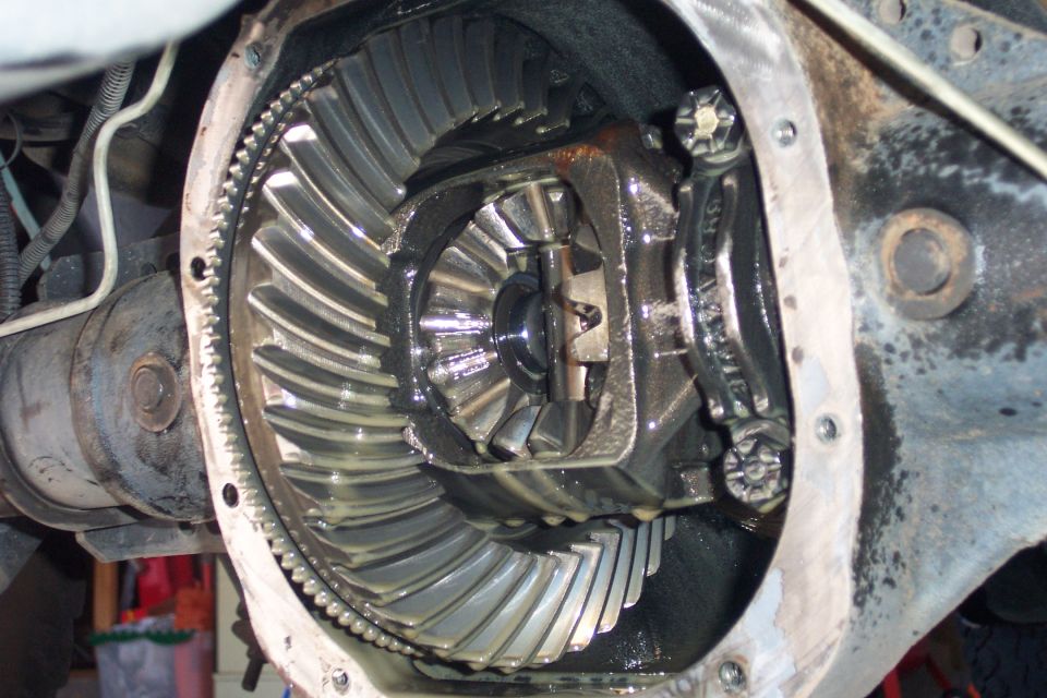 Differential gears with a ring gear and pinion visible, showing wear and grease