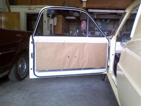 1967 Ford Ranchero - View of the interior door panel and open door of a light-colored vehicle, with another dark vehicle partially visible.