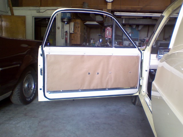 1967 Ford Ranchero interior door panel, tan, with white trim, open door, another vehicle visible