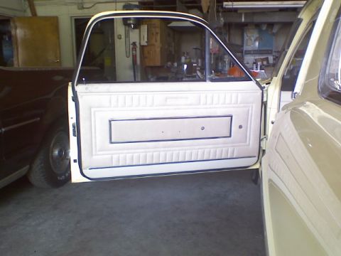 1967 Ford Ranchero - Close-up view of a vehicle's interior door panel and window frame, with another vehicle partially visible in the background.