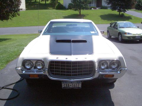 1972 Ford Ranchero - Head-on front view of a white Ford Ranchero in a driveway, showing the egg-crate grille with FORD hood lettering, quad round headlights, ch…