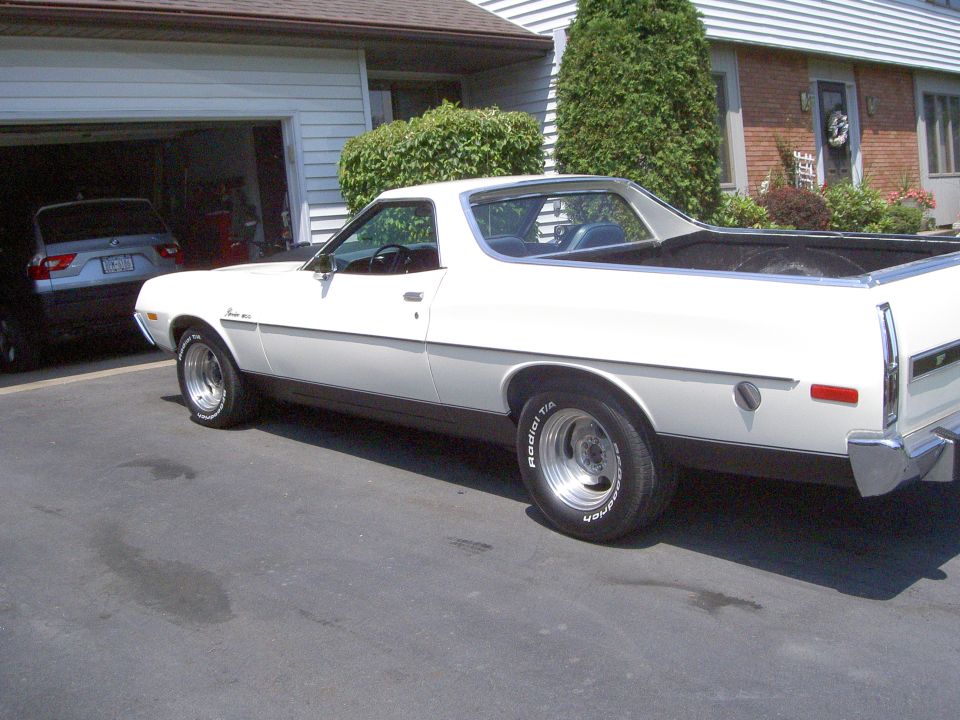 White Ford Ranchero rear three-quarter view in a driveway on polished slotted mags
