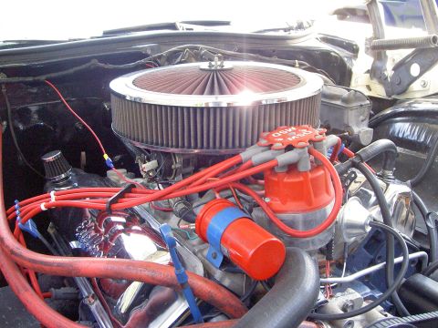 1972 Ford Ranchero - Engine bay close-up of a V8 topped with a chrome-lidded open-element round air cleaner over a four-barrel carburetor, fed by red MSD plug w…