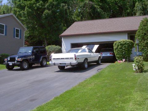 1972 Ford Ranchero - White Ford Ranchero coupe utility parked in a suburban driveway with its hood raised, seen from the driver-side rear three-quarter angle sh…