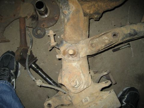 1995 Ford Bronco - Close-up view of heavily rusted vehicle suspension components and a driveshaft.