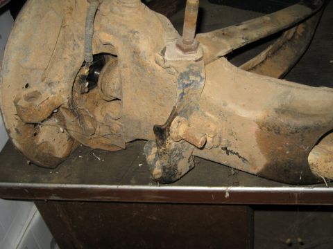 1995 Ford Bronco - A close-up view of a heavily corroded vehicle suspension component.