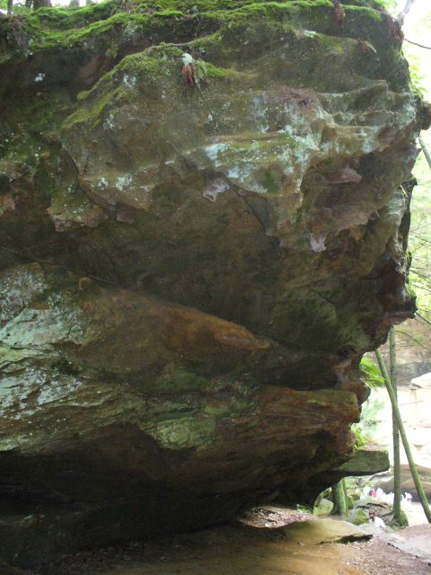 1991 Ford Probe - A large, moss-covered rock formation dominates the scene, with trees and a stream visible in the background.